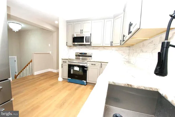 a kitchen with stainless steel appliances kitchen island a stove a sink and a refrigerator