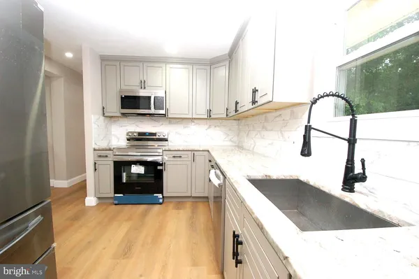 a kitchen with stainless steel appliances kitchen island granite countertop a sink and a stove