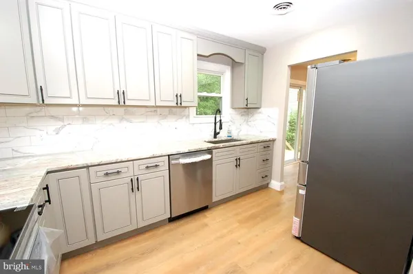 a kitchen with white cabinets and sink