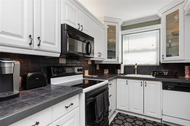a kitchen with stainless steel appliances granite countertop a sink stove microwave and cabinets