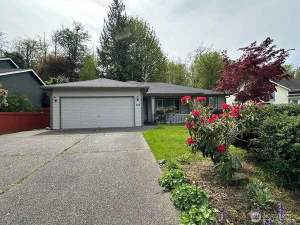 a front view of house with a yard and potted plants