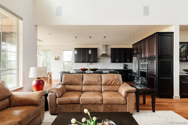 a living room with furniture white walls and kitchen view