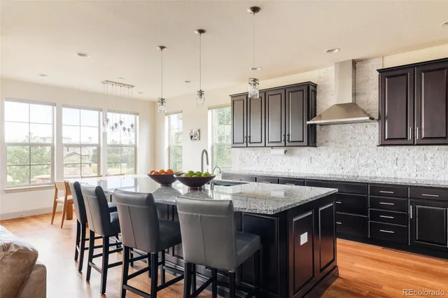 a kitchen with stainless steel appliances granite countertop a sink a stove a table and chairs