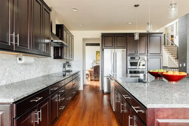 a kitchen with stainless steel appliances granite countertop a sink stove and refrigerator