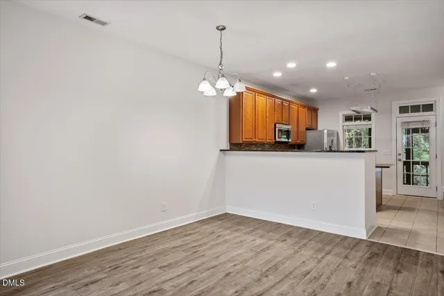 a view of a kitchen with a sink and dishwasher with wooden floor