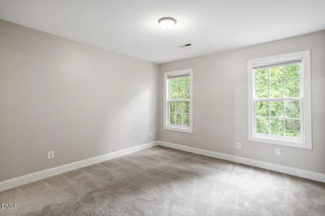 an empty room with closet and windows