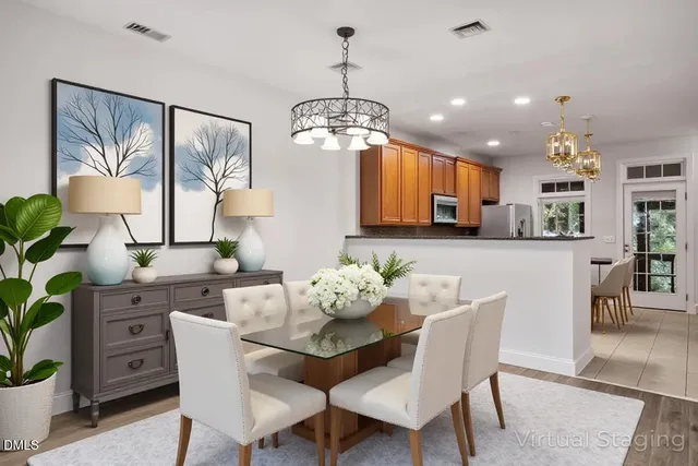 a view of a dining room with furniture a potted plant and a chandelier