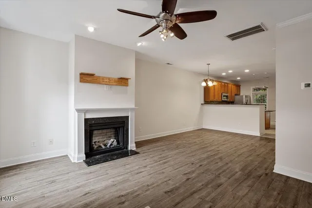 an empty room with wooden floor a fireplace and a window