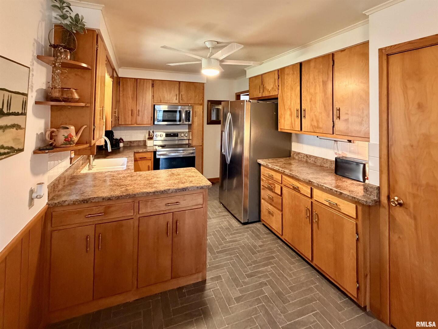1043 14th Avenue South Clinton, IA 52732 - Photo 9 of 23 a kitchen with stainless steel appliances a refrigerator and wooden cabinets