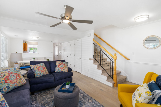 732 North 200 E Street Springville, UT 84663 - Photo 11 of 36 Open-concept living area featuring wood-finish flooring, a ceiling fan with integrated lighting, and a carpeted staircase with wrought iron balusters and a wood handrail