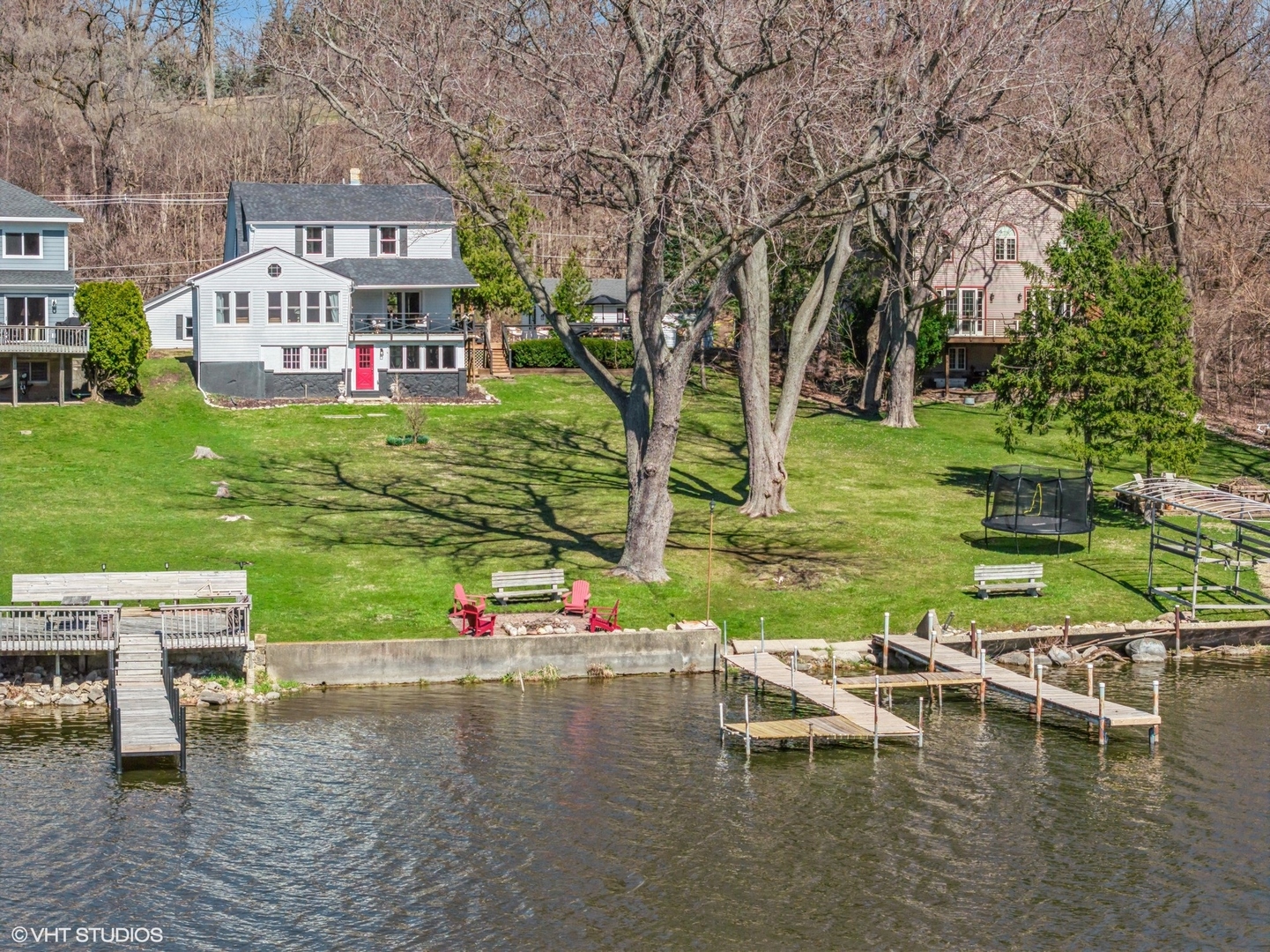 a view of a lake with a house swimming pool and outdoor seating
