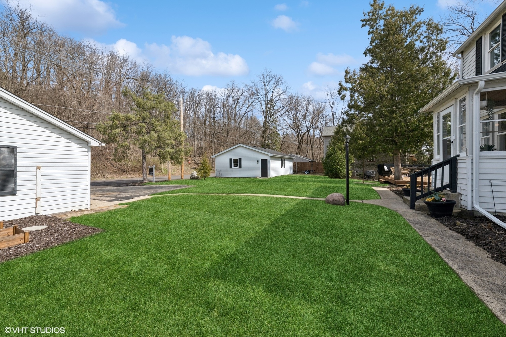705 Spring Beach Way Cary, IL 60013 - Photo 30 of 47 a view of a white house in front of a big yard with plants and large trees