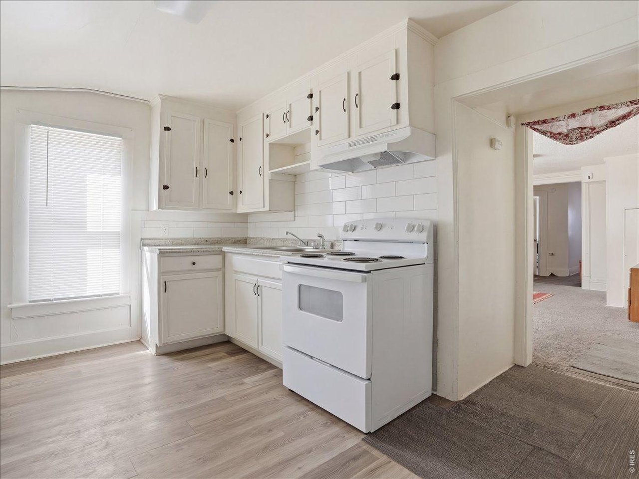 228 13th Street Greeley, CO 80631 - Photo 11 of 29 a kitchen with cabinets appliances a sink and a window