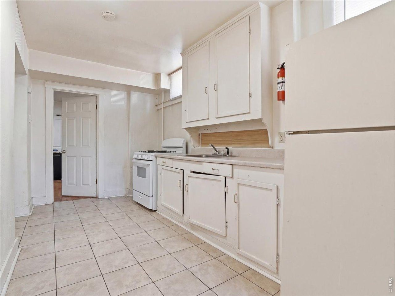 228 13th Street Greeley, CO 80631 - Photo 12 of 29 a kitchen with white cabinets and white appliances