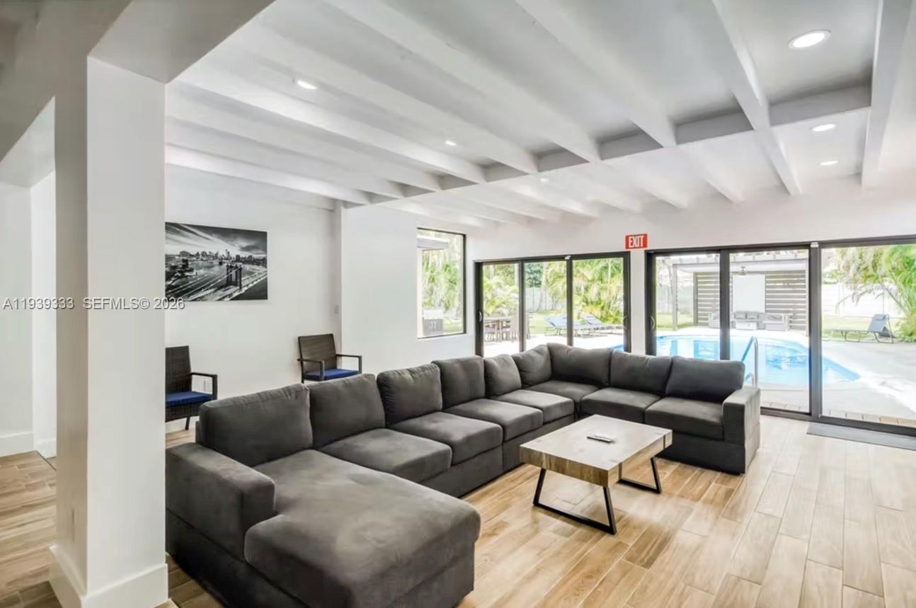 a living room with furniture and a large window with balcony view