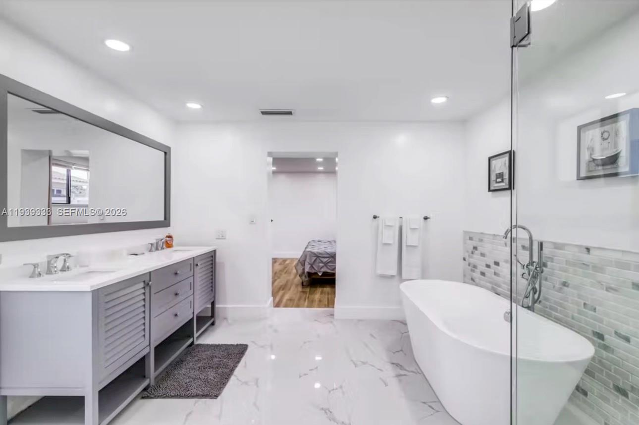 2639 Monroe Street Hollywood, FL 33020 - Photo 11 of 27 a bathroom with a tub a sink and a mirror
