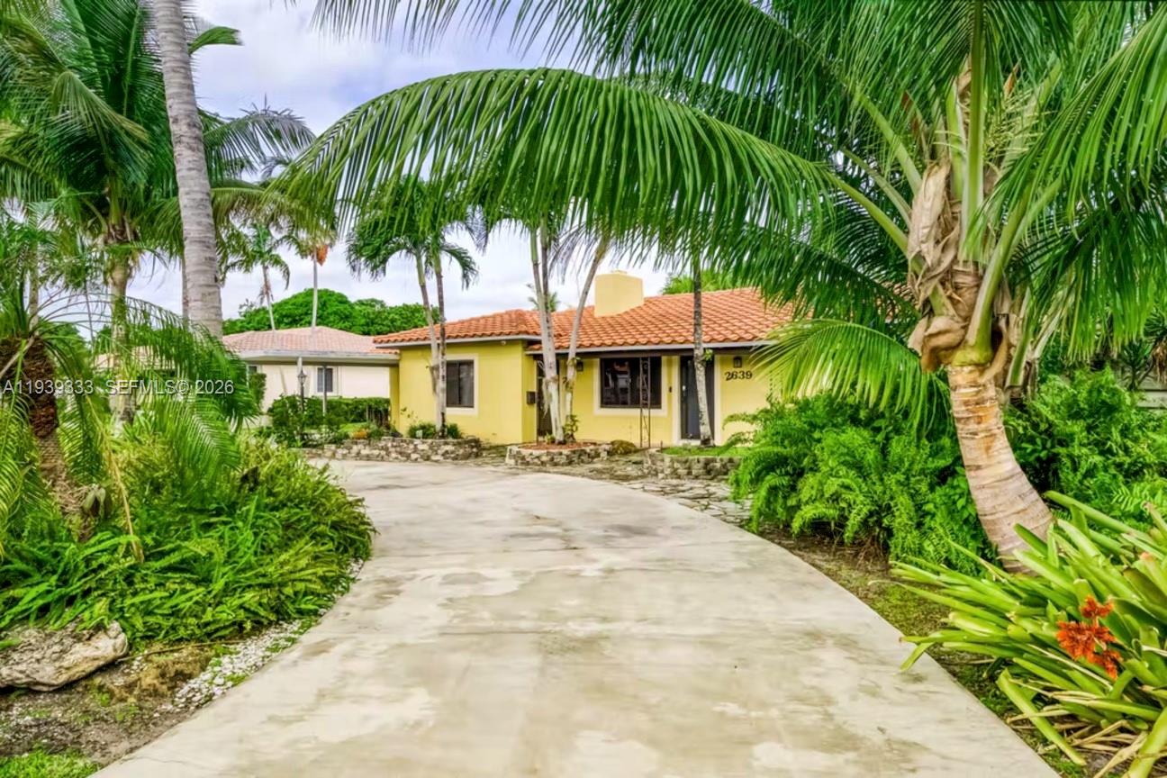 2639 Monroe Street Hollywood, FL 33020 - Photo 2 of 27 a view of a white house with a yard and sitting area