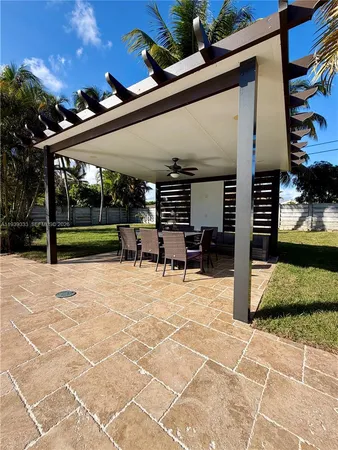 a view of a patio with table and chairs potted plants