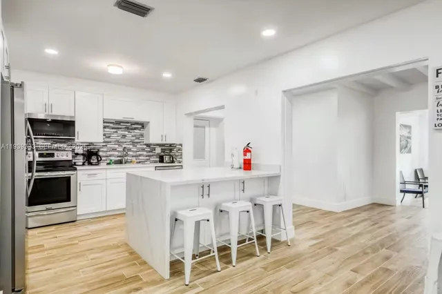 a kitchen with white cabinets and stainless steel appliances