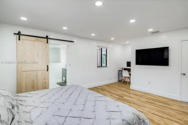 a bedroom with a bed and a flat screen tv