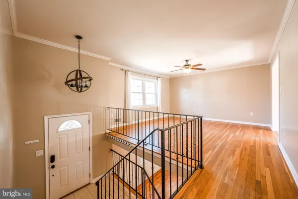 a view of a hallway with wooden floor and stairs