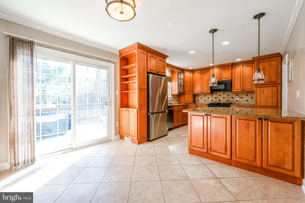 a open kitchen with stainless steel appliances granite countertop a stove a sink dishwasher and a refrigerator with cabinets