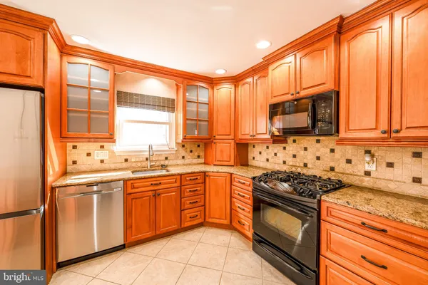 a kitchen with stainless steel appliances a sink a stove and cabinets