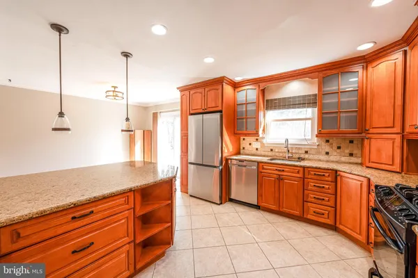 a kitchen with stainless steel appliances granite countertop a sink and a refrigerator
