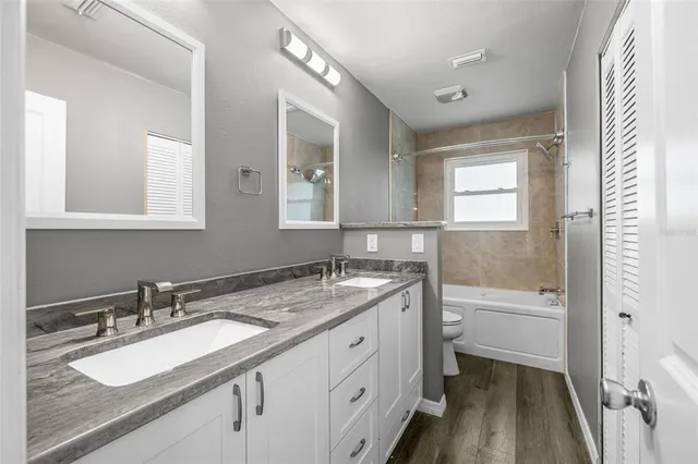 a bathroom with a granite countertop sink mirror and bathtub