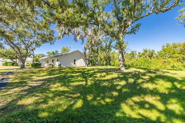 a view of yard with swimming pool and trees
