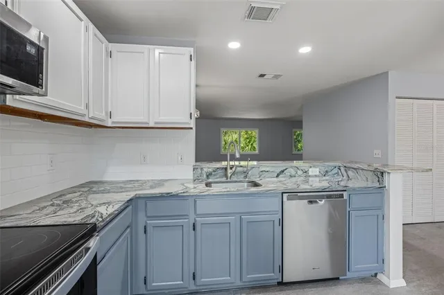 a kitchen with cabinets appliances a sink and a counter top space