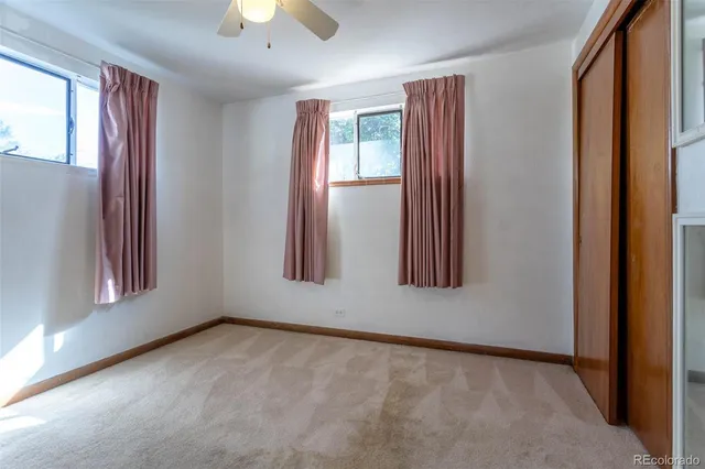 an empty room with windows and closet