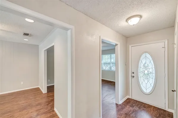 a view of a hallway with painting and a window