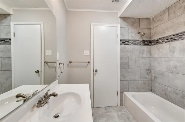 a bathroom with a tub sink and mirror
