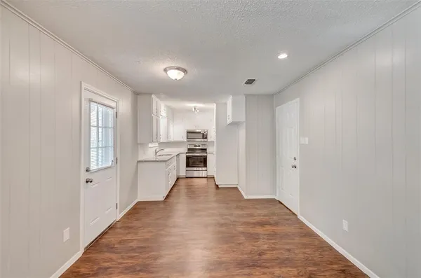 a view of a kitchen with a sink and dishwasher a refrigerator with wooden floor