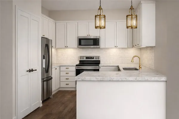 a kitchen with stainless steel appliances granite countertop a refrigerator a stove a sink and white cabinets