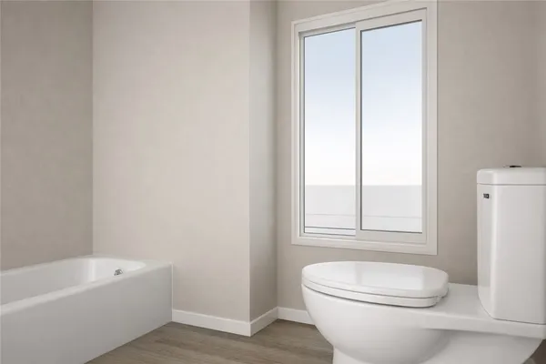 a bathroom with a toilet a sink a window and bathtub