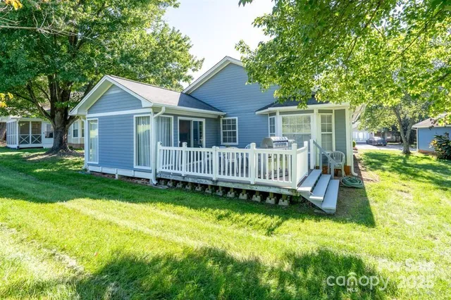 a view of a house with a yard and deck