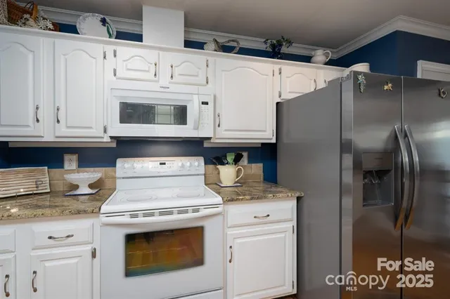 a kitchen with stainless steel appliances granite countertop a refrigerator sink and stove