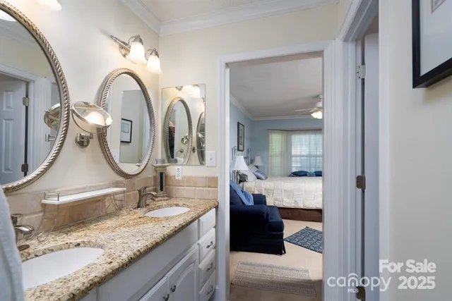 a en suite bathroom with a granite countertop sink and a mirror