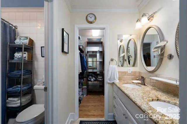 a en suite bathroom with a granite countertop sink and a mirror