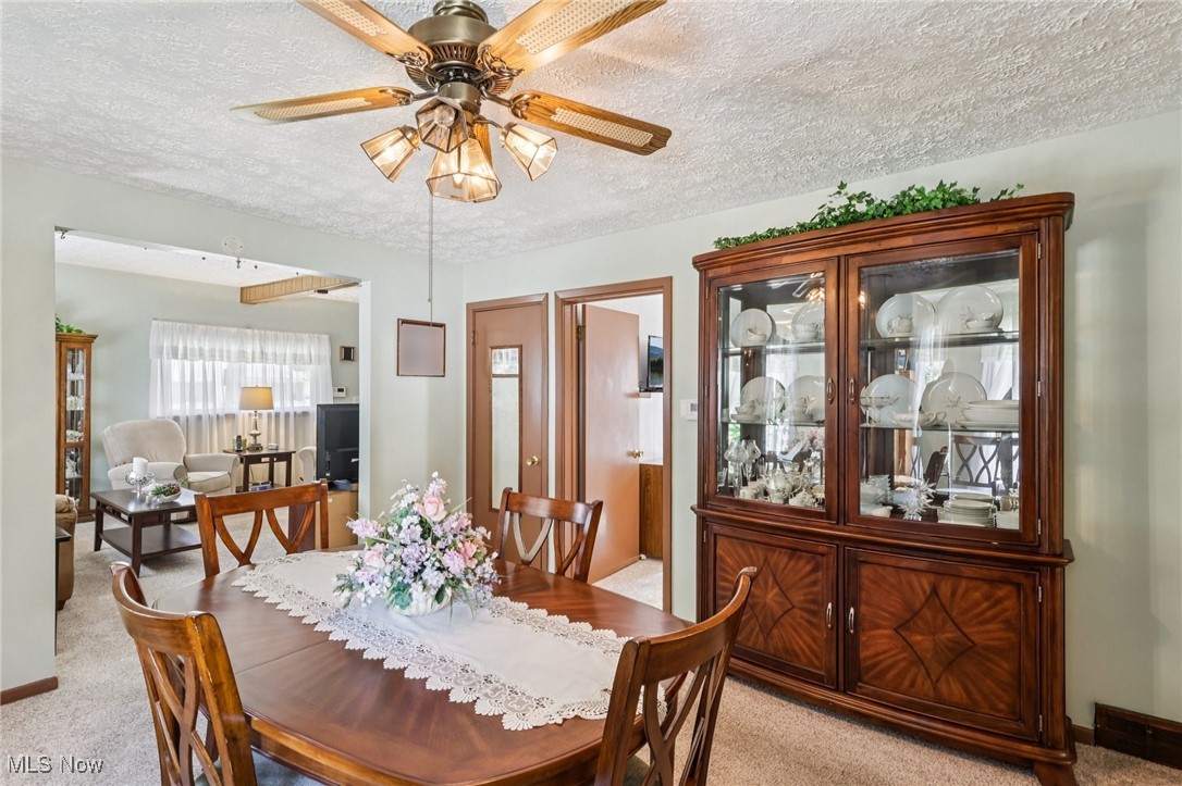 10818 Dixon Road Cleveland, OH 44111 - Photo 11 of 44 Dining area with a textured ceiling, light colored carpet, and ceiling fan