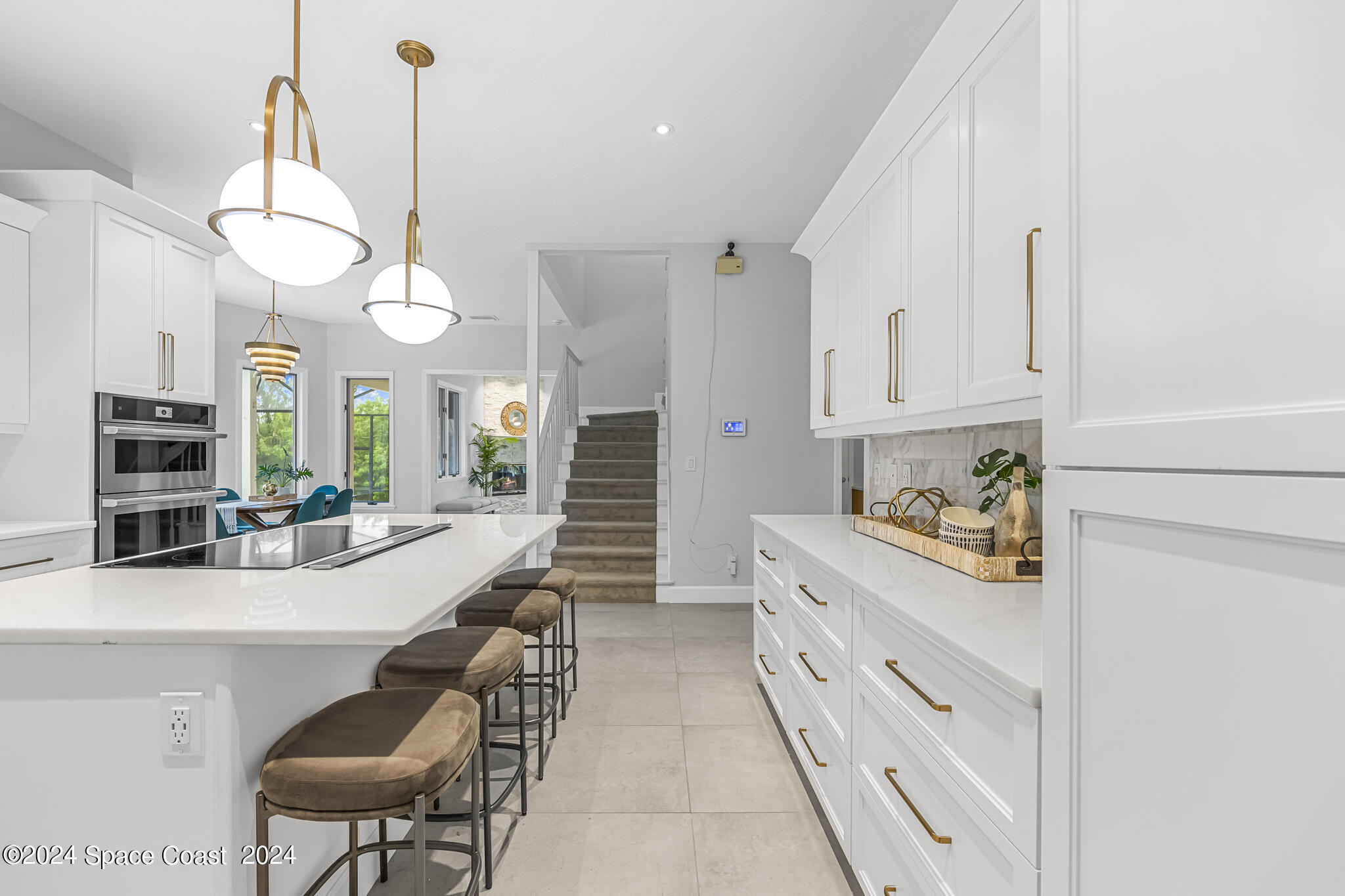 3671 Big Pine Road Melbourne, FL 32934 - Photo 11 of 60 a kitchen with stainless steel appliances kitchen island granite countertop a stove a sink a dining table and chairs with wooden floor