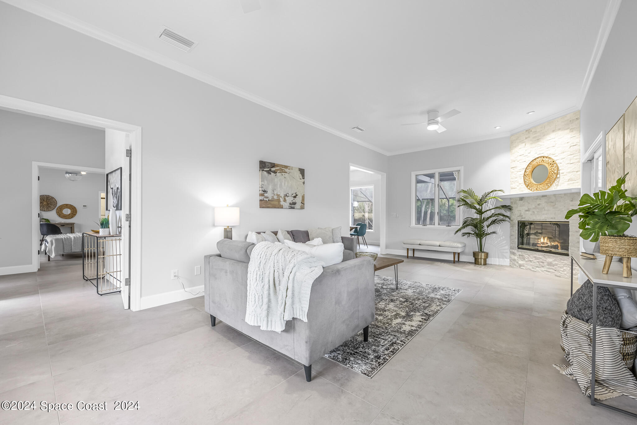 3671 Big Pine Road Melbourne, FL 32934 - Photo 20 of 60 a spacious bedroom with a bed a table and painting on the wall