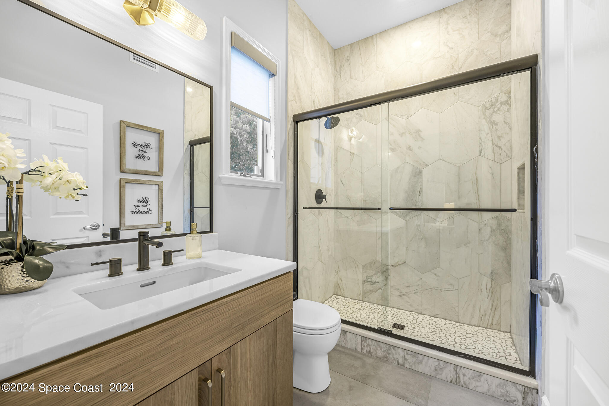 3671 Big Pine Road Melbourne, FL 32934 - Photo 27 of 60 a bathroom with a shower sink vanity mirror and toilet