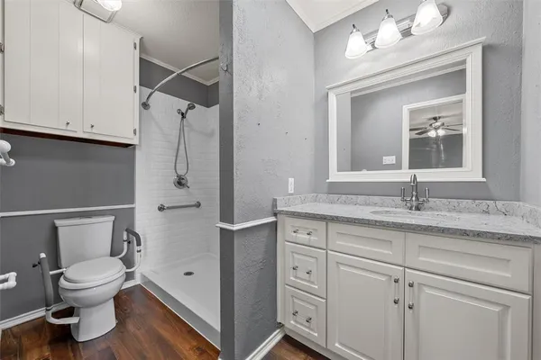 a bathroom with a granite countertop sink toilet and shower