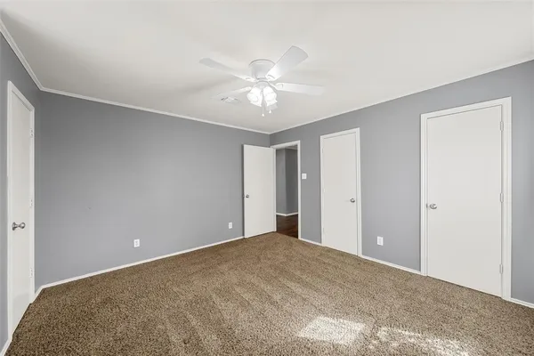 a view of a big room with a ceiling fan and a window