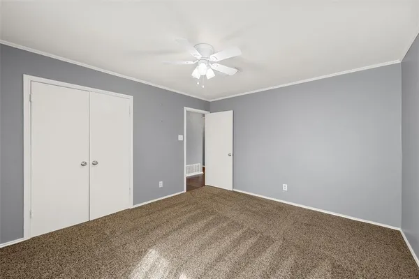 a view of an empty room and chandelier fan