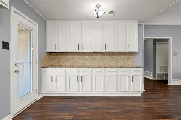 a kitchen with granite countertop white cabinets and a sink