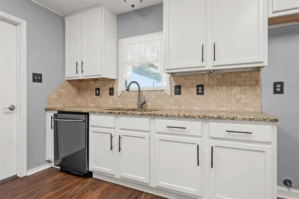 a kitchen with granite countertop white cabinets and white appliances